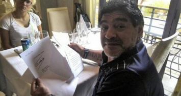 Le joueur de football Diego Maradona lisant la lettre qui porte la signature de son ami Fidel Castro.