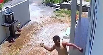 Cet extrait d’une vidéo montre un homme lançant une pierre pour briser une vitre et pénétrer dans une maison.