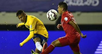 L'attaquant brésilien Neymar shoote devant le milieu de terrain péruvien Joel Sanchez, lors du match de leurs équipes à Temuco (Chili) le 14 juin 2015.