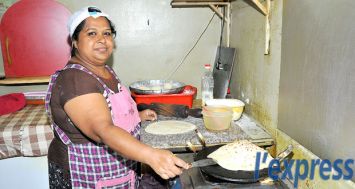 Sunita, cachée derrière les rideaux de la cuisine, prépare des faratas chauds pour ses clients.