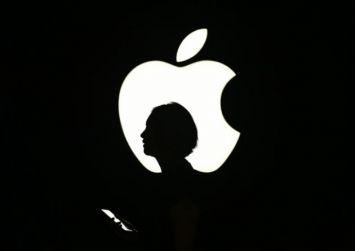AFP/AFP/Archives - Une personne passe devant un logo Apple à San Francisco en Californie, le 9 septembre 2015.