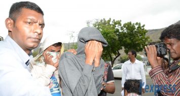 (Photo d’archives) Les deux profanateurs de tombes se cachant le visage lors de leur arrestation le 31 octobre 2013.