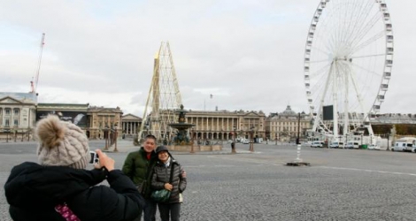 Des touristes prennent la pose devant la place de la Concorde à Paris le 30 novembre 2015.