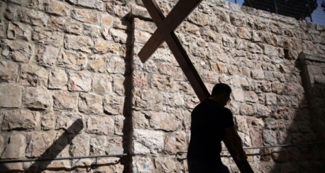 Un pèlerin catholique transporte une croix de bois le long de la Via Dolorosa à Jérusalem, lors de la procession du vendredi saint, le 25 mars 2016.