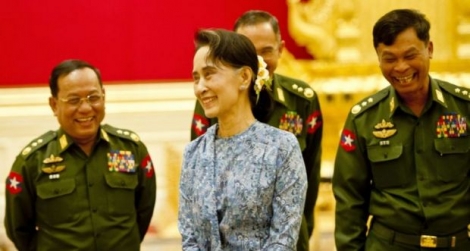 Aung San Suu Kyi, fraîchement élue à la tête d'un super ministère comprenant notamment Affaires étrangères et Éducation, partage un moment de joie avec des généraux lors de la cérémonie de passation des pouvoirs le 30 mars 2016 à Naypyidaw en Birmanie 