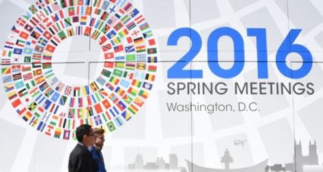 Deux hommes passent devant un panneau annonçant le meeting du monde de la finance à Washington, le 13 avril 2016.