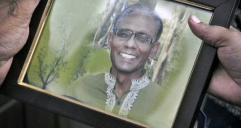 Une personne tient la photo du professeur Rezaul Karim Siddique tué à la machette, à Rajshahi au Bangladesh, le 23 avril 2016 