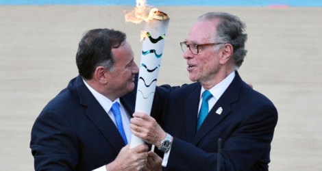 Le patron des Jeux de Rio Carlos Nuzman (d) reçoit la flamme olympique des mains de Spyros Kapralos, chef du comité olympique grec, le 27 avril 2016 à Athènes.