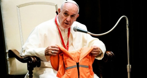 Le pape François montre lors d'une réunion avec des jeunes, le 28 mai 2016 au Vatican, le gilet de sauvetage d'un jeune qui s'est noyé en Méditerranée en essayant de rejoindre l'Europe.