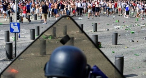 Un poilcier derrière son bouclier face à des supporteurs anglais lors de heurts, le 11 juin 2016 à Marseille