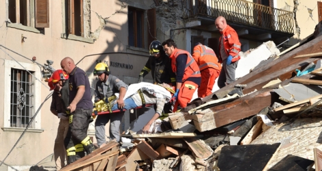Des sauveteurs sortent un homme des décombres à Arquata del Tronto, dans la région des Marches, le 24 août 2016, après le séisme qui a frappé le centre de l'Italie.