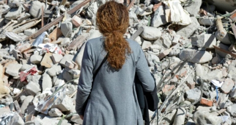 Une femme devant les décombres d'un immeuble détruit par le séisme à Amatrice, le 26 août 2016.