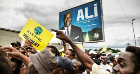 Une manifestation de soutien à Jean ping devant un panneau pour la campagne d'Ali Bongo, à Libreville, le 26 août 2016.