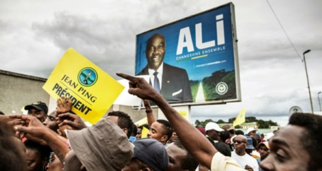Une manifestation de soutien à Jean ping devant un panneau pour la campagne d'Ali Bongo.