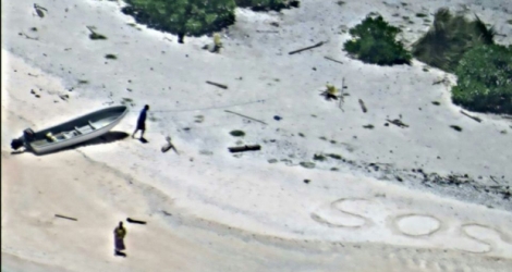 Image fournie par la marine américaine montrant un SOS écrit sur le sable photographié par une équipe de recherches sur l'île d'East Fayu, en Micronésie, le 25 août 2016.