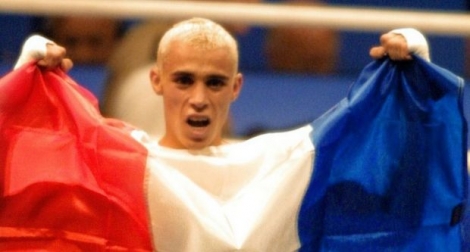 Brahim Asloum agite le drapeau français après son titre de champion olympique en finale des 48 kg face l'Espagnol Rafael Lozano Munoz à Sydney, le 30 septembre 2000