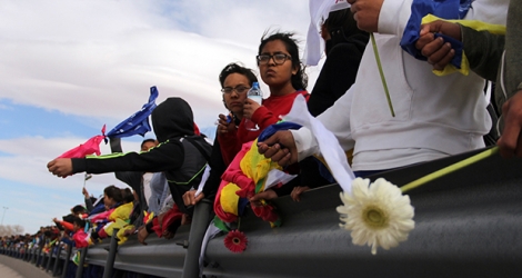 Sous les regards d'une patrouille frontalière américaine, les manifestants ont formé une chaîne humaine d'environ 1,5 km, se tenant par les bras, certains drapés dans des drapeaux mexicains ou vêtus de blanc.