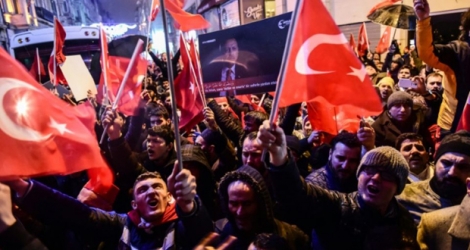Des manifestants brandissent des drapeaux turcs le 11 mars 2017 devant le consulat néerlandais à Istanbul 