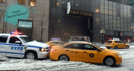 Une voiture de police pousse un taxi embourbé dans la neige, à New York, devant la Trump Tower, le 14 mars 2017 .