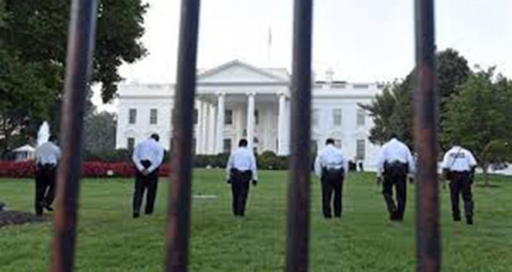 Des agents de sécurité marchent sur la pelouse de la Maison-Blanche.