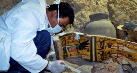 Un archéologue travaille sur un sarcophage découvert dans une tombe de l'époque pharaonique à côté de la ville de Louxor, en Egypte, le 18 avril 2017 .