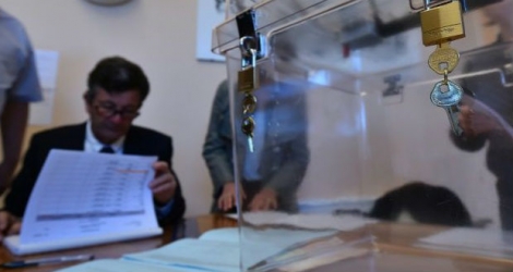 Le maire de Solemes (Pays de la Loire) Pascal Lelievre (C) et ses assesseurs préparent les bulletins de vote pour le premier tour de l'élection présidentielle, le 23 avril 2017.