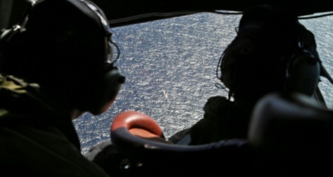 Des membres d'équipage d'un avion de recherches survolent une zone dans le sud de l'Océan indien espérant détecter des débris du vol MH370, le 4 avril 2014.