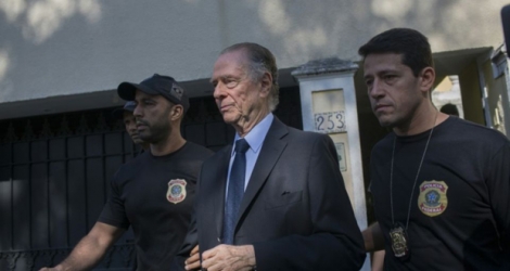 Le président du Comité olympique brésilien Carlos Nuzman (c) quitte son domicile escorté par la police, le 5 octobre 2017 à Rio de Janeiro.
