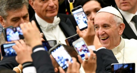 Le pape François au milieu de la foule au Vatican le 21 décembre 2016 alors que les gens prennent des photos de lui avec leur téléphone portable.