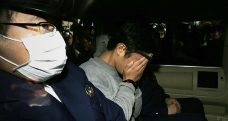 Le Japonais Takahiro Shiraishi (c), escorté par des policiers est conduit en voiture au bureau du procureur de Tokyo, le 1er novembre 2017