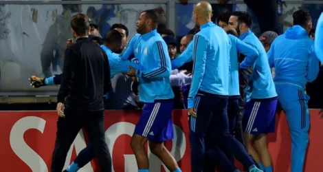 Le Marseillais Patrice Evra retenu par ses coéquipiers alors qu'il assène un coup de pied à un supporter de son équipe à Guimaraes, le 2 novembre 2017