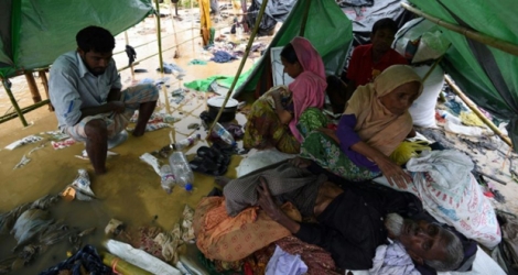 Des réfugiés Rohingyas ayant fui la Birmanie se protègent des intempéries sous un abri de fortune dans un camp au Bangladesh.