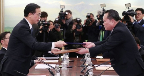 Le ministre sud-coréen de l'unification Cho Myung-Gyun (g) serre la main du responsable de la délégation nord-coréenne Ri Son-Gwon (d) lors d'une rencontre à Panmunjom, le 9 janvier 2018