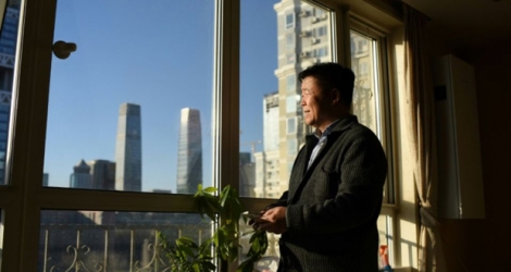 Le Chinois Zou Yi regarde par la fenêtre le ciel bleu, le 11 janvier 2018 à Pékin