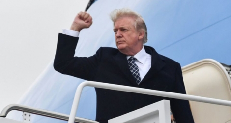 Le président américain Donald Trump lève le poing avant de monter à bord de son avion le 12 janvier.