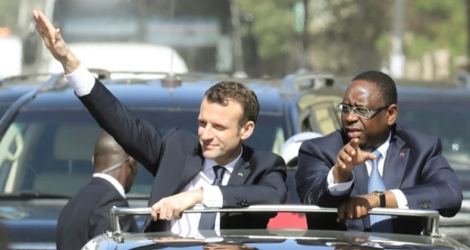 Emmanuel Macron, au côté du président sénégalais Macky Sall, salue la foule lors de sa visite à Dakar le 2 février 2018.