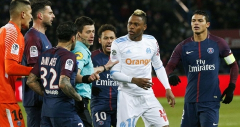 L'attaquant marseillais Clinton Mua Njie (2d) discute avec le défenseur du PSG, Dani Alves, à la droite de l'arbitre, lors du match les opposant, le 25 février 2018 à Paris.