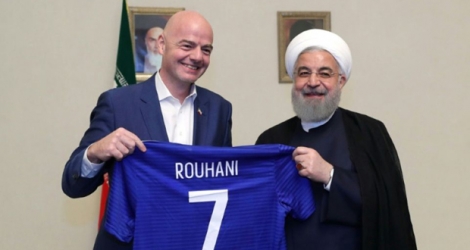 Le président iranien Hassan Rohani montre et le président de la Fifa, Gianni Infantino, tenant un maillot avec le nom de Rohani dessus, à Téhéran le 1er mars 2018.