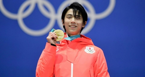 Le Japonais Yuzuru Hanyu pose sur le podium avec sa médaille d'or après avoir remporté le concours individuel messieurs de patinage artistique aux JO, le 17 février 2018 à Pyeongchang