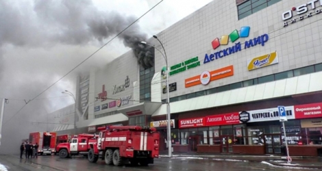 Photo obtenue auprès du ministère russe des Situations d'urgence le 25 mars 2018 montrant des camions de pompiers luttant contre un incendie dans un centre de commercial de Kemerovo en Sibérie occidentale.