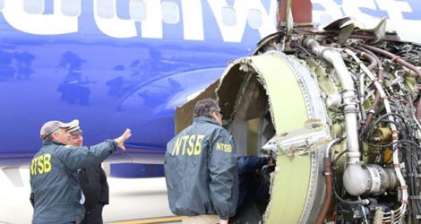 Des enquêteurs de l'organisme fédéral américain de sécurité dans les transports, le NTSB, examinent le 18 avril 2018 les dégâts après l'explosion du moteur d'un Boeing de la compagnie Southwest Airlines la veille 