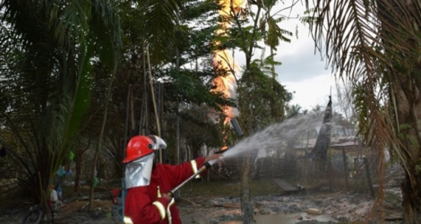 Un pompier indonésien combat l'incendie d'un puits de pétrole illégal à Peureulak, le 25 avril 2018 