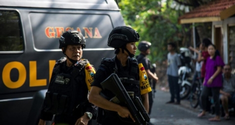 Des policiers indonésiens patrouillent à l'extérieur d'une église après une attaque suicide, à Surabaya en Indonésie le 13 mai 2018