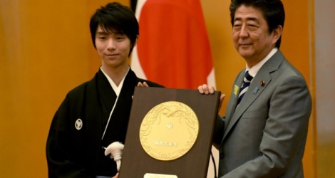 Le double-champion olympique de patinage artistique japonais, Yuzuru Hanyu (g), reçoit le Prix d'honneur de la nation des mains du Premier ministre Shinzo Abe, le 2 juillet 2018 à Tokyo.