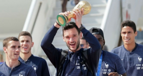Le capitaine et gardien de l'équipe de France Hugo Lloris brandit la Coupe du monde, à l'arrivée à Roissy le 16 juillet 2018.