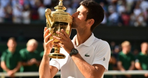 Le Serbe Novak Djkovic embrasse le trophée après sa victoire face au Sud-Africain Kevin Anderson en finale à Wimbledon, le 15 juillet 2018
