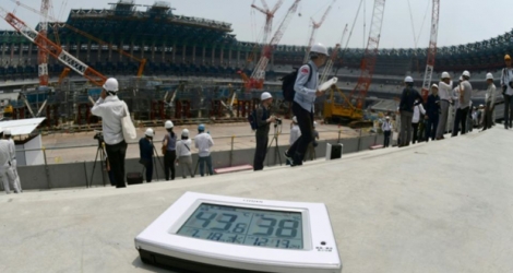 Un thermomètre électronique montre une température de 43°C lors d'une visite de presse du chantier du nouveau stade olympique de Tokyo, le 18 juillet 2018. 