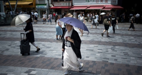 Des Japonaises se protègent du soleil dans une rue de Tokyo, le 23 juillet 2018.