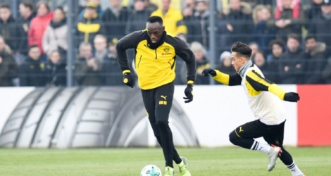 La légende jamaïcaine du sprint Usain Bolt (g) lors d'une séance d'entraînement avec Dortmund, le 23 mars 2018 à Dortmund.