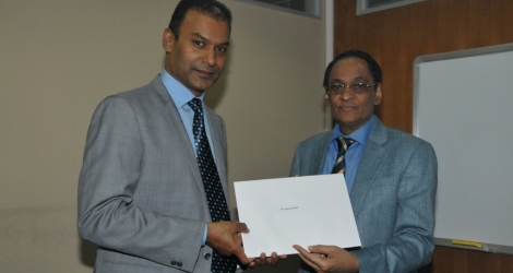 Vinash Gopee recevant le document officiel qui l'autorise à exercer comme consul hono-raire, des mains du ministre des Affaires étrangères, Vishnu Lutchmeenaraidoo, le 19 mai 2016.